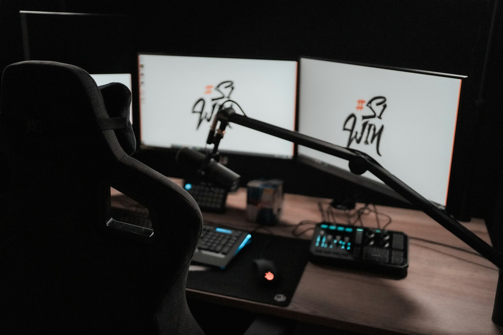 Computer desk with two monitors and a microphone, streaming setup